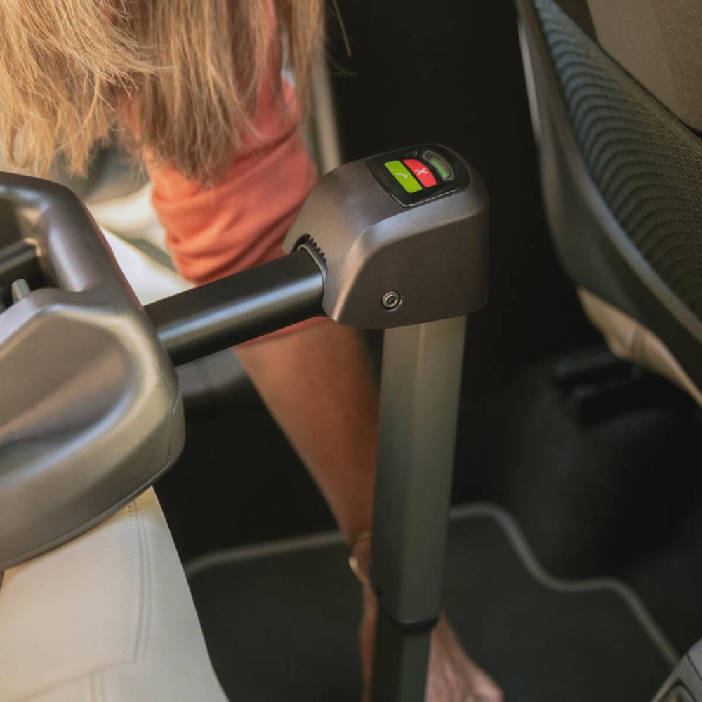 Woman installing the Tavo pet car seat vehicle base into the backseat and securing the stability load leg.